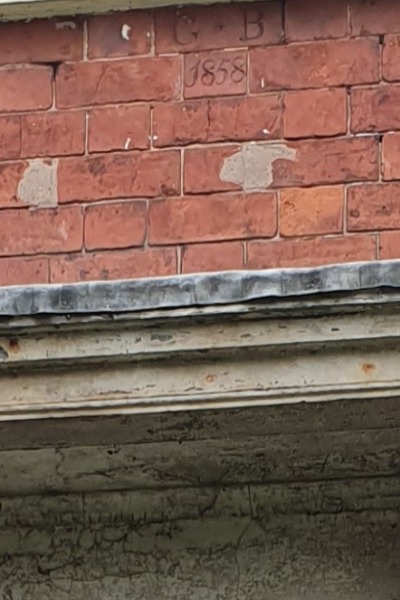 G.B. stands for George Bealby. 1858 is presumeably the year the house was built.